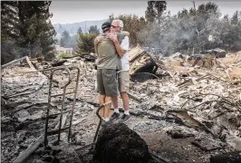  ?? HECTOR AMEZCUA / SACRAMENTO BEE ?? Dan Spraggins (right), 79, of Lake Redding Estates, gets a hug from a friend at the burned-out remains of his home on Friday. “This was a beautiful home,” Spraggins said.