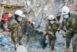  ?? EMIN OZMEN/THE NEW YORK TIMES ?? Rescue workers clear rubble Feb. 14 in Adiyaman, Turkey. Adherence to the country’s building codes is at issue in the wake of this month’s earthquake.