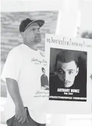  ??  ?? Jason Reyes, Sr., holds an image of his cousin Anthony Nuñez, at the rally in San Jose on Thursday.