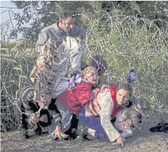  ?? REUTERS ?? Syrian migrants cross under a fence as they enter Hungary at the border with Serbia, near Roszke, in August last year.