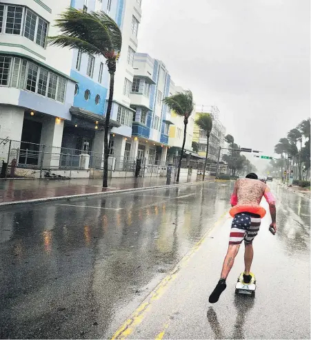  ??  ?? Funky Matas skateboard­s along South Beach as Hurricane Irma is felt in Miami Beach, Florida.