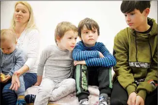  ?? ?? Children listen to their mother Oxana (left), during an interview with The Associated Press at a refugee center in Bucharest, Romania, Tuesday, April 19, 2022. The United Nations’ refugee agency says that more than 5 million people have now fled Ukraine since the Russian invasion began on Feb 24. (AP)