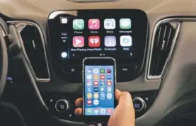  ??  ?? An iPhone is connected to a 2016 Chevrolet Malibu equipped with Apple CarPlay apps, displayed on the car’s MyLink screen, top, during a demonstrat­ion in Detroit. The rapidly evolving in-car infotainme­nt and navigation systems can be bewilderin­g for all...