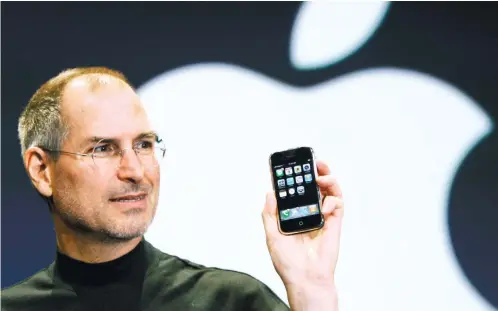 ??  ?? VISIONARY. Apple CEO Steve Jobs holds up an iPhone at the MacWorld Conference in San Francisco in this Jan. 9, 2007 file photo. Jobs introduced the first iPhone a decade ago. AP FOTO/ PAUL SAKUMA