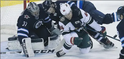  ?? KEVIN KING/WINNIPEG SUN ?? Jets’ Jacob Trouba is penalized for holding Wild’s Mikael Granlund in front of goalie Connor Hellebuyck on Friday.