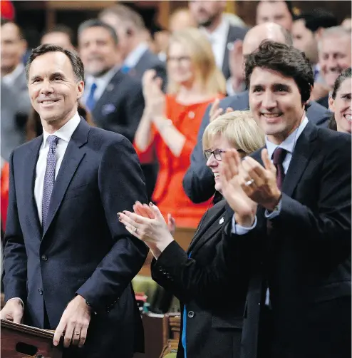  ?? ADRIAN WYLD / THE CANADIAN PRESS ?? Finance Minister Bill Morneau, left, is applauded by fellow Liberals as he delivers his fall economic statement.