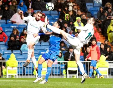  ?? — AFP photo ?? Real Madrid’s Welsh forward Gareth Bale (R) and Real Madrid’s Spanish defender Dani Carvajal (L) vie with Getafe’s Japanese midfielder Gaku Shibasaki during the Spanish league football match Real Madrid CF against Getafe CF at the Santiago Bernabeu...