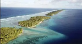  ??  ?? This aerial photo shows the thin strip of coral atolls separating the ocean from the lagoon in Majuro, Marshall Islands.