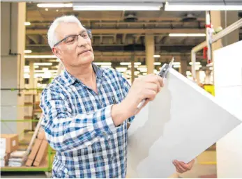  ?? FOTO: FELIX KÄSTLE/DPA ?? Alno-Mitarbeite­r bei der Endkontrol­le von Schranktei­len: „Wir brauchen aber eine breitere Verantwort­ungsbereit­schaft der Mitarbeite­r, sie müssen sich stärker einbringen“, sagt Alno-Chef Jochen Braun.