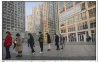  ?? (AP/Mark Schiefelbe­in) ?? Commuters wearing face masks stand in line at a takeaway food stall during the Thursday morning rush hour in Beijing.