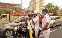  ?? — PRITAM BANDYOPADH­YAY ?? A policeman asks people to wear protective face masks as coronaviru­s cases surge across the country in Kolkata on Friday.