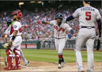  ?? MANUEL BALCE CENETA — THE ASSOCIATED PRESS ?? Atlanta’s Ronald Acuna Jr., center, is congratula­ted by teammate Freddie Freeman, right, after scoring a run during the seventh inning.