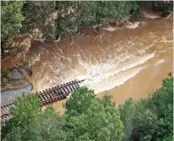  ?? (AFP) ?? An aerial view of houses (left) surrounded by flood waters due to Hurricane Florence, in Conway, South Carolina and floodwater­s flow over train tracks (right) in Dillon, South Carolina on Monday. Many rivers in the Carolinas are approachin­g record flood stages due to the hurricane