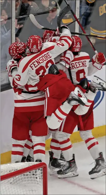  ?? STUART CAHILL — BOSTON HERALD ?? Boston University celebrates its game-winning goal in overtime during a 2-1 Hockey East semifinal win over Providence on Friday night.