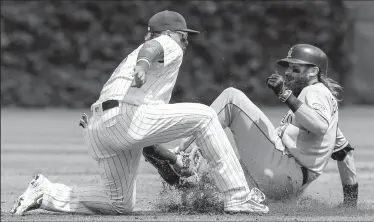  ?? JOSE M. OSORIO/TRIBUNE NEWS SERVICE ?? Chicago Cubs second baseman Javier Baez, left, puts the tag on the Colorado Rockies' Charlie Blackmon, who is caught stealing second base to end the second inning at Wrigley Field in Chicago on Friday.