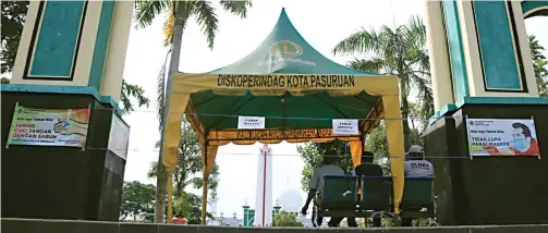  ?? MOKHAMMAD ZUBAIDILLA­H/JAWA POS RADAR BROMO ?? STERIL DARI PENGUNJUNG: Kawasan Alun-Alun Kota Pasuruan ditutup lantaran PPKM masih diterapkan. Waktu pembukaan taman dan alun-alun belum bisa ditentukan.