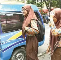  ?? GALIH WICAKSONO/JAWA POS ?? LEBIH AMAN: Dua pelajar tetap memilih naik angkutan umum ketika berangkat dan pulang sekolah.