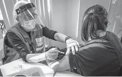  ?? JERRY JACKSON/BALTIMORE SUN ?? Nurse Aimee Carlesi administer­s a COVID-19 vaccine to mental health therapist Laura Gershen, of Woodstock, during a clinic at the Howard County Health Department on Wednesday afternoon.