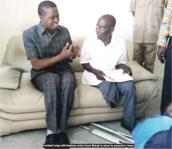  ??  ?? President Lungu with landmine victim Enock Makabi to whom he presented a house