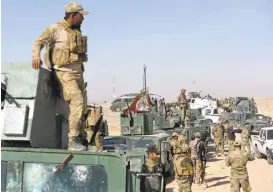  ?? BULENT KILIC/AGENCE FRANCE-PRESSE VIA GETTY IMAGES ?? Iraqi pro-government forces hold a position on the frontline on Saturday near the village of Tall al-Tibah, some 30 kilometres south of Mosul, during an operation to retake the city.