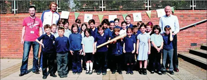  ??  ?? Chris Tomlinson towers over the Akiva pupils, who also get to hold the Olympic torch. Also pictured is Leslie Lyndon ( right), who will be one of the torch bearers