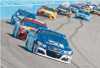  ?? ASSOCIATED PRESS FILE PHOTO ?? Jamie McMurray, front, drives through the first turn during a NASCAR Cup Series race at Phoenix Internatio­nal Raceway in March.