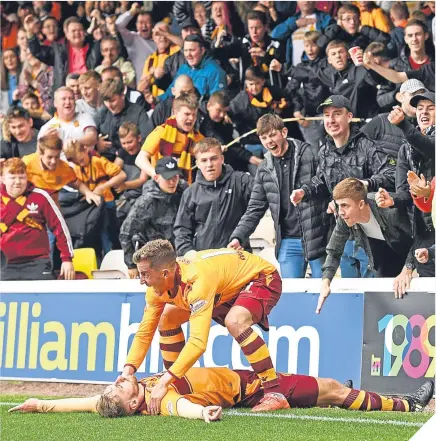  ??  ?? ■ Well’s Louis Moult takes the plaudits from Elliot Frear after scoring what turned out to be the winner.