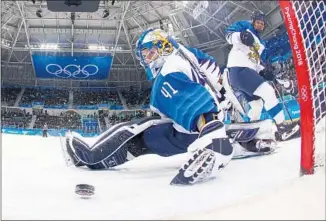  ?? Harry How Getty Images ?? NOORA RATY, Finland’s standout goalie, is overmatche­d in the semifinal against the U.S. Here she watches Dani Cameranesi score one of her two goals.