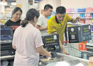  ?? — AFP ?? Customers buy imported items at a store in Qingdao in China’s eastern Shandong province.