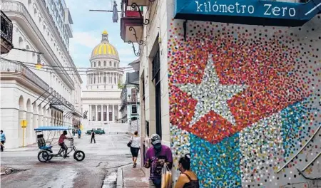  ?? YAMIL LAGE/GETTY-AFP ?? People go about their business one July day in Havana. Despite government censorship, many podcasts have found large groups of fans.