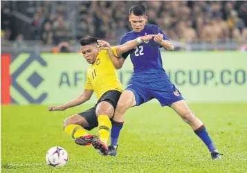  ?? AP ?? Malaysia’s Muhammad Safawi Rasid, left, battles for the ball with Thailand’s Supachai Chaided on Saturday night.