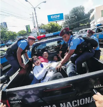  ?? ALFREDO ZUNIGA / THE ASSOCIATED PRESS ?? Anti-government protesters are taken away by police as security forces disrupt their march in Managua, Nicaragua, on Sunday. The protests, calling for President Daniel Ortega’s resignatio­n, have been ongoing since April.