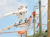  ?? ORLANDO SENTINEL ?? Florida Power and Light Co. workers install stronger wood poles as part of a 102-pole storm strengthen­ing project in 2010.