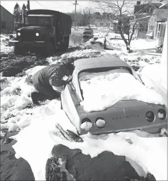  ?? TIM SAVARD — THE ASSOCIATED PRESS ?? A National Guardsman checks a stranded car on Feb. 9, 1978, in Hampton, N.H., to see if anyone was trapped inside.