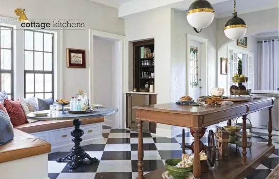  ?? ?? |ABOVE| THE KITCHEN IS OPEN. The kitchen’s open feeling is evident from the perspectiv­e of standing in the kitchen and looking at the long hallway with French and stained-glass doors that connect to the formal dining room. The nook faces the courtyard. Brooke chose a zinc table for the nook to add another texture to the room. She had it custom made with a cast iron base and an oval-shaped plywood piece wrapped in zinc. The cushion on the bench is a faux leather vinyl. The bench has a storage drawer. The built-in apothecary hutch used to be a door.