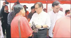  ??  ?? Abang Johari (centre) distribute­s fresh beef to the public at the celebratio­n. At right is Ahmad Shabery.