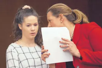  ?? CORY MORSE/THE GRAND RAPIDS PRESS ?? Erin Blayer, left, listens to Michigan Assistant Attorney General Angela Povilaitis before giving her statement during Larry Nassar’s sentencing at Eaton County Circuit Court in Charlotte on Wednesday.