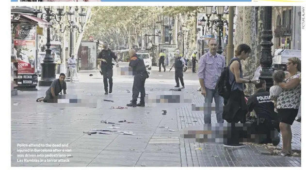  ??  ?? Police attend to the dead and injured in Barcelona after a van was driven into pedestrian­s on Las Ramblas in a terror attack