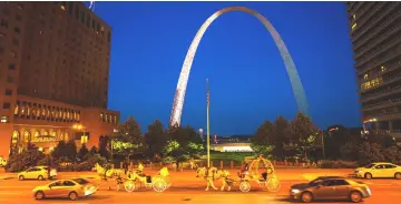  ??  ?? Horse-drawn carriages and cars share the road near the Gateway Arch near the Mississipp­i River in downtown St. Louis. The Arch features a new museum and visitors centre.