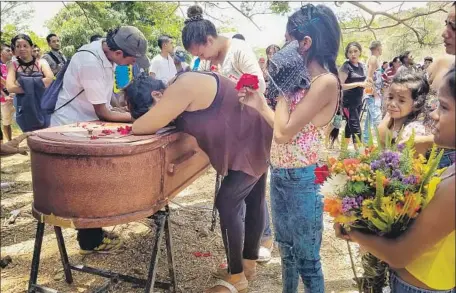  ?? Heberlizet­h Gonzalez EPA/Shuttersto­ck ?? RELATIVES WEEP during burial services for an inmate who died in a fire last week at a prison in Valencia, Venezuela, that killed 68.