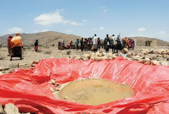  ??  ?? REUTERS Displaced people gather at an artificial water pan near Habaas town of Awdal region in Somaliland in April 2016. As East Africa reels from the worst drought in a century, scientific studies show the impact of drought is more severe because of...