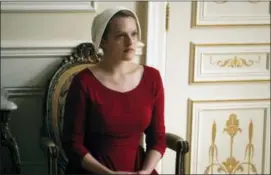  ??  ?? Elisabeth Moss as Offred in a scene from “The Handmaid’s Tale,” premiering Wednesday on Hulu with three episodes.