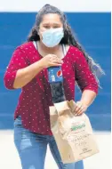  ?? AP ?? Deported Guatemalan Vanessa Diaz looks towards her family as she picks up the food they brought her, identified by her name, at the site where Guatemalan­s returned from the US are being held in quarantine for two weeks in Guatemala City.