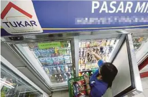  ?? FILE PIC ?? A customer shopping at a sundry shop, which is part of the Tukar programme, in Puchong.