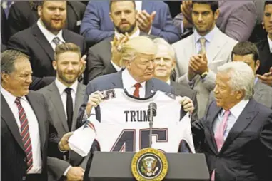  ??  ?? Donald Trump hosts the Super Bowl champion Patriots at the White House, including coach Bill Belichick (l.) and owner Robert Kraft (r.), but many players, including Tom Brady, are not there.