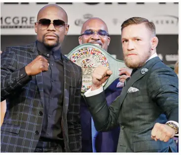  ??  ?? Floyd Mayweather Jr., left, and Conor McGregor pose for photograph­ers during a news conference Wednesday in Las Vegas. The two are scheduled to fight in a boxing match Saturday in Las Vegas. (AP)