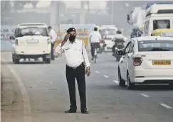  ??  ?? 0 A police officer directs traffic in New Delhi