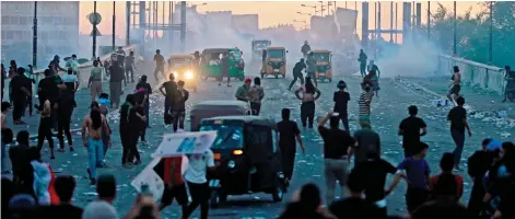  ?? — AFP photo ?? Sadr’s supporters clash with Iraqi security forces in Tahrir Square in the centre of Iraq’s capital Baghdad during a parliament session in the nearby highsecuri­ty Green Zone across the Tigris river.