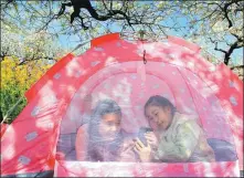  ??  ?? Two children relax in a tent at a fruit plantation on the outskirts of Huaibei, Anhui province.