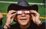  ?? Jon Shapley/Staff photograph­er ?? Al Angel Flores holds his protective glasses as he watches the eclipse in Eagle Pass.